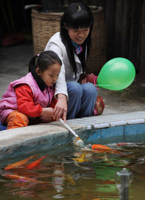 اطعام السمك بواسطة رضاعات الاطفال في الصين ( صور + فيديو ) Feeding-fish-with-baby-bottle-06