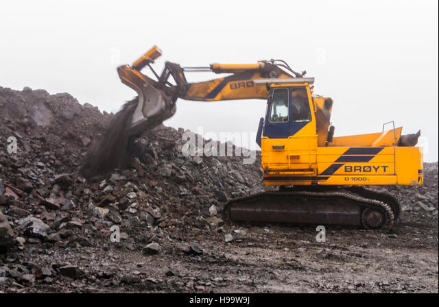 BROYT escavatori A-broyt-tracked-loader-dumps-a-bucket-of-rocks-in-a-quarry-in-heavy-h99w9j