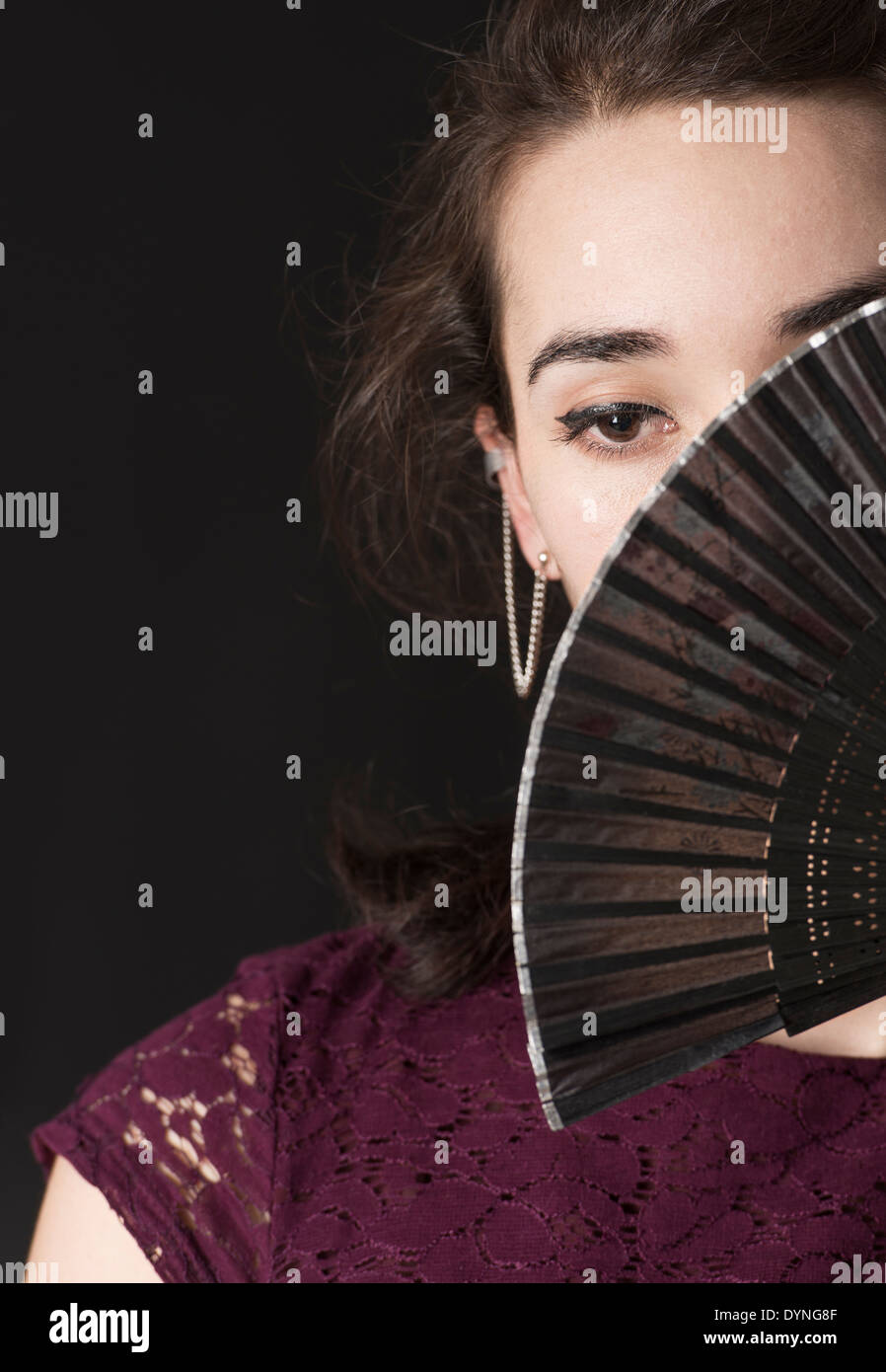 Lepeze - Page 12 Pensive-hispanic-woman-covering-her-face-with-foldable-hand-fan-DYNG8F