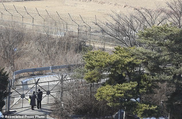 The Serious Side - part 4 - Page 9 2000338-5230353-Visitors_stand_near_the_military_wire_fence_at_the_Imjingak_Pavi-a-125_1514961429704