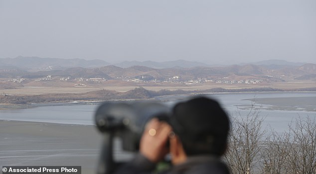 The Serious Side - part 4 - Page 9 2000340-5230353-A_visitor_uses_binoculars_to_see_the_North_Korea_side_from_the_u-a-126_1514961429705