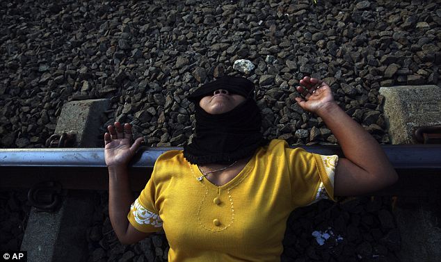 بالصور  والفيديو // فى اندونيسيا الاعتصام بالنوم فوق قضبان القطارات من اجل العلاج (( خاص أمواج )) Article-0-0D43E7E200000578-898_634x377