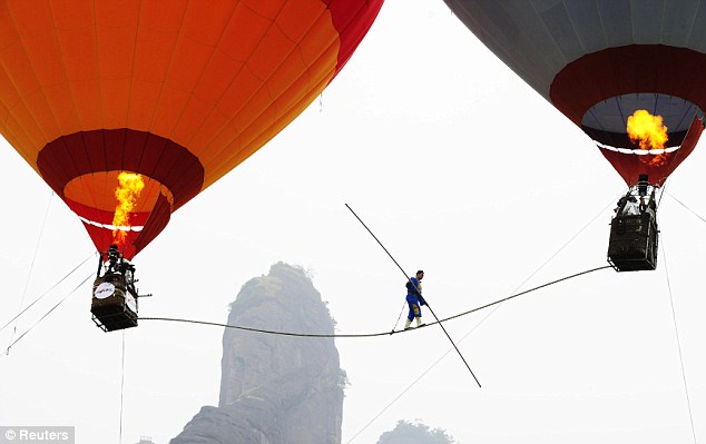 بالصور  // فى الصين بهلوان متهور يمشى على الحبل بين بالونين على ارتفاع 650 قدم  Article-0-0D548DF300000578-11_634x399