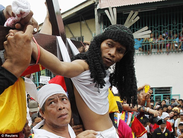 بالصور // المسيحيون على الصلبان في إعادة  يوم الجمعة العظيمة من وفاة المسيح في الفلبين Article-2126024-127D0BAD000005DC-666_634x477