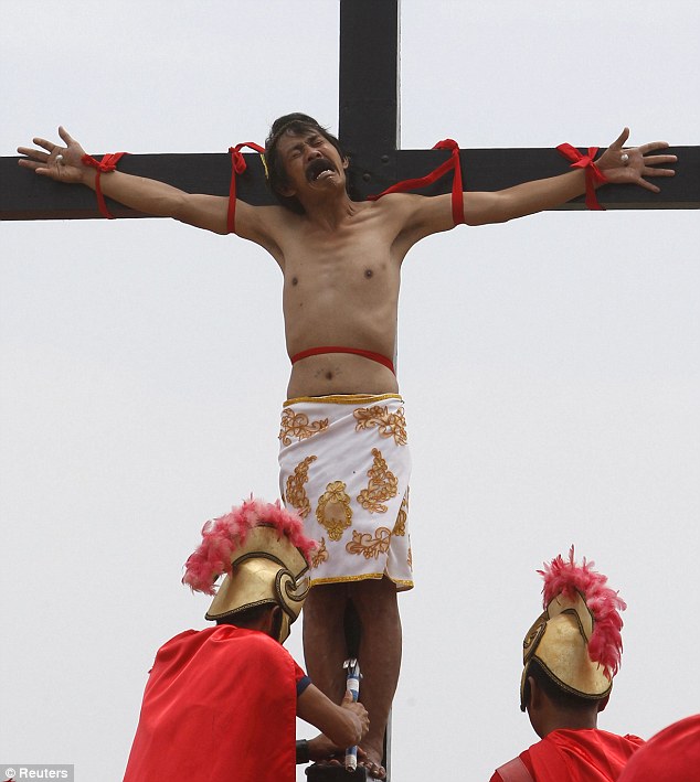 بالصور // المسيحيون على الصلبان في إعادة  يوم الجمعة العظيمة من وفاة المسيح في الفلبين Article-2126024-127D605A000005DC-821_634x709