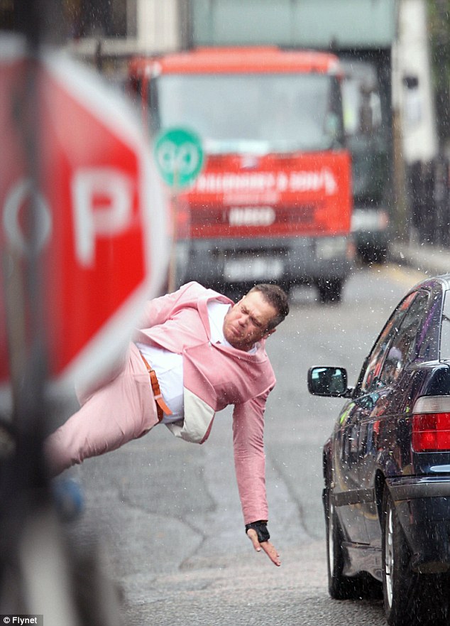 Robbie Williams' body double takes the hit as cars smash into him for the singer's new hard-hitting music video  Article-2189253-14921D03000005DC-437_634x881