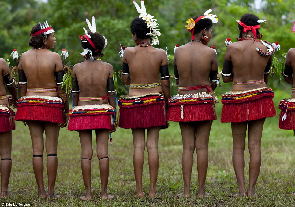 In charge: Girls are encouraged to take part in 'battles' and dance topless, with most choosing to wear red grass skirts, shells, feathers and fresh flowers