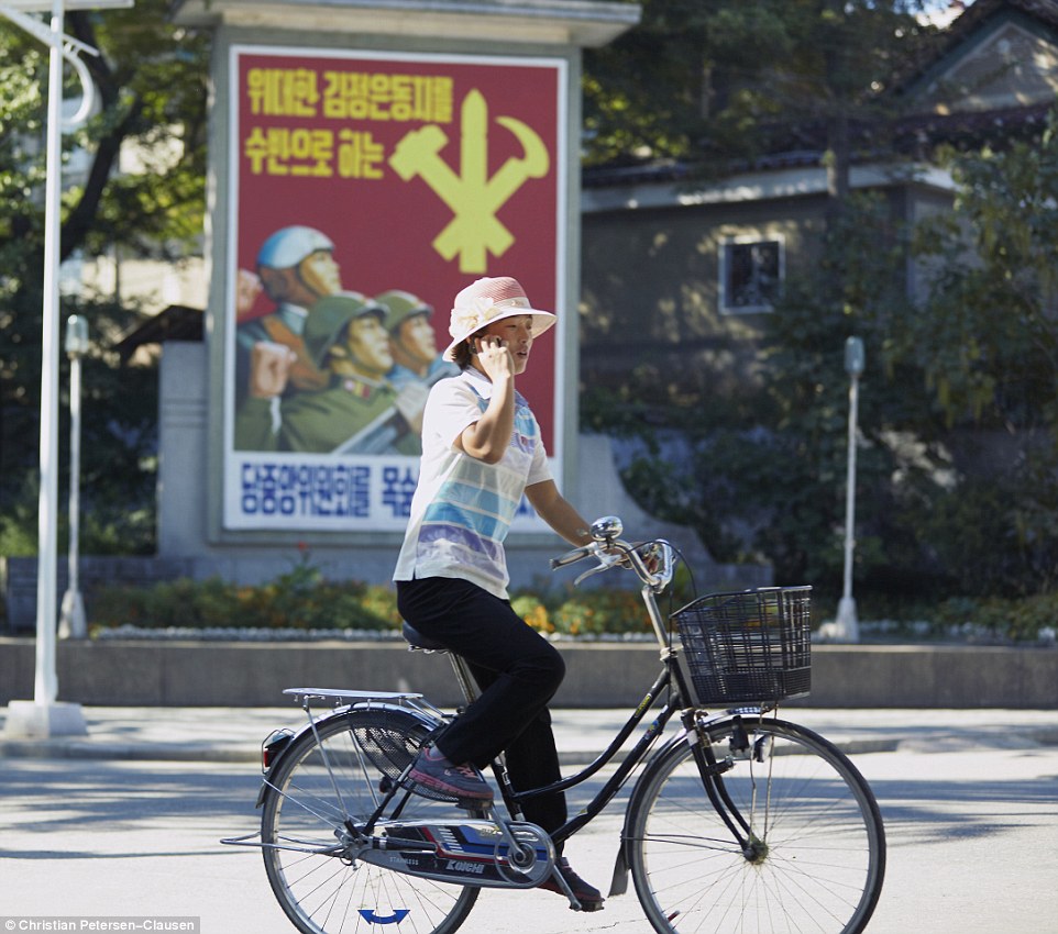 Cum este de fapt viața în Coreea de Nord 2EB976FD00000578-3330557-A_cyclist_passes_by_a_propaganda_sign_on_his_mobile_phone_with_s-m-120_1448301238087