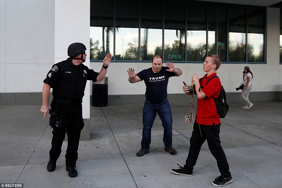 Masovni napadi na trumpove skupove 34DFA35B00000578-3625441-A_Trump_protester_holds_his_hands_up_in_the_air_as_he_tells_a_po-a-193_1465067667608