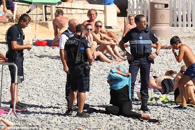 The Burkini Cops: Armed poLice order Muslim woman to remove her burkini on packed Nice beach 3785A7CA00000578-3754395-image-a-39_1471979587008