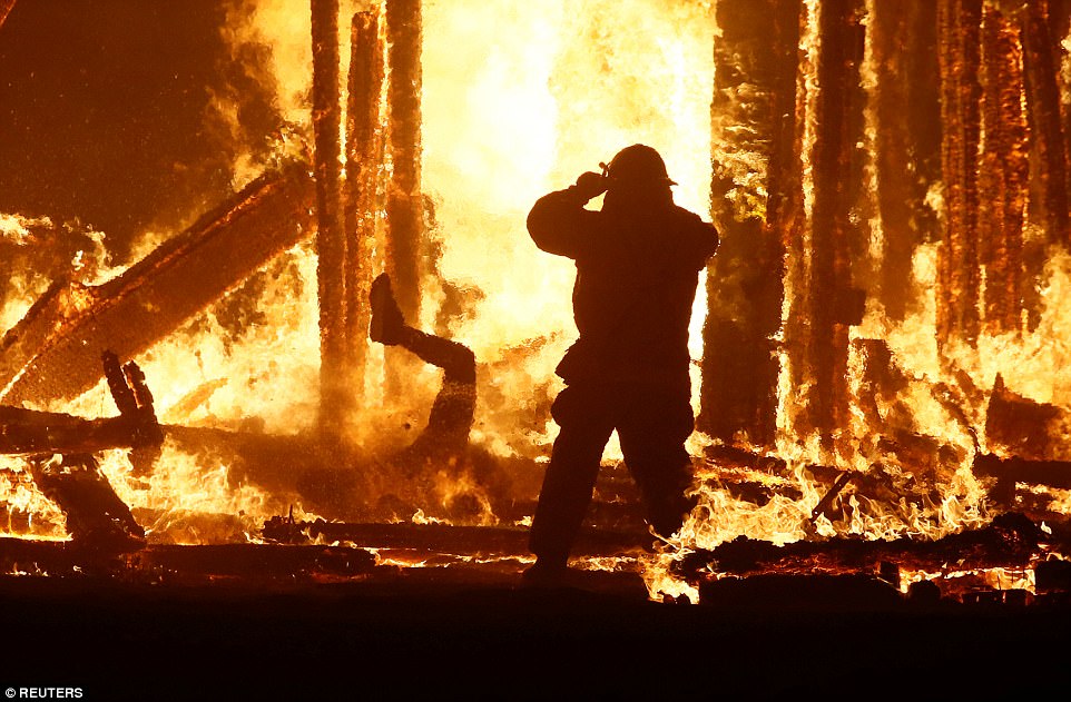 Stunned Burning Man festival-goers watch in horror as man dodges firefighters and rangers to dive into flames of blazing effigy 43DB2DC900000578-4848026-A_firefighter_watches_as_a_Burning_Man_participant_L_evades_a_ch-a-20_1504427167518