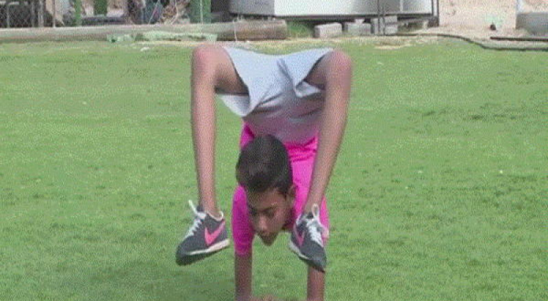 طفل فلسطيني يستعد لدخول غينيس بجسد ملتف على شكل كرة Bb166