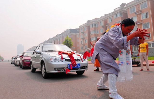 صور امراة صينية تسحب بشعرها 6 سيارات  Woman_pulls_six_cars_03