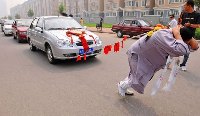 صور امراة صينية تسحب بشعرها 6 سيارات  Woman_pulls_six_cars_04