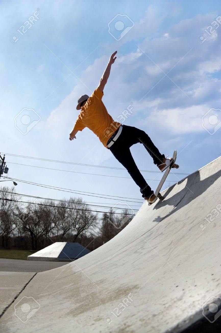 Skateboarding 5469352-Portrait-of-a-young-skateboarder-skating-down-a-ramp-at-the-skate-park--Stock-Photo