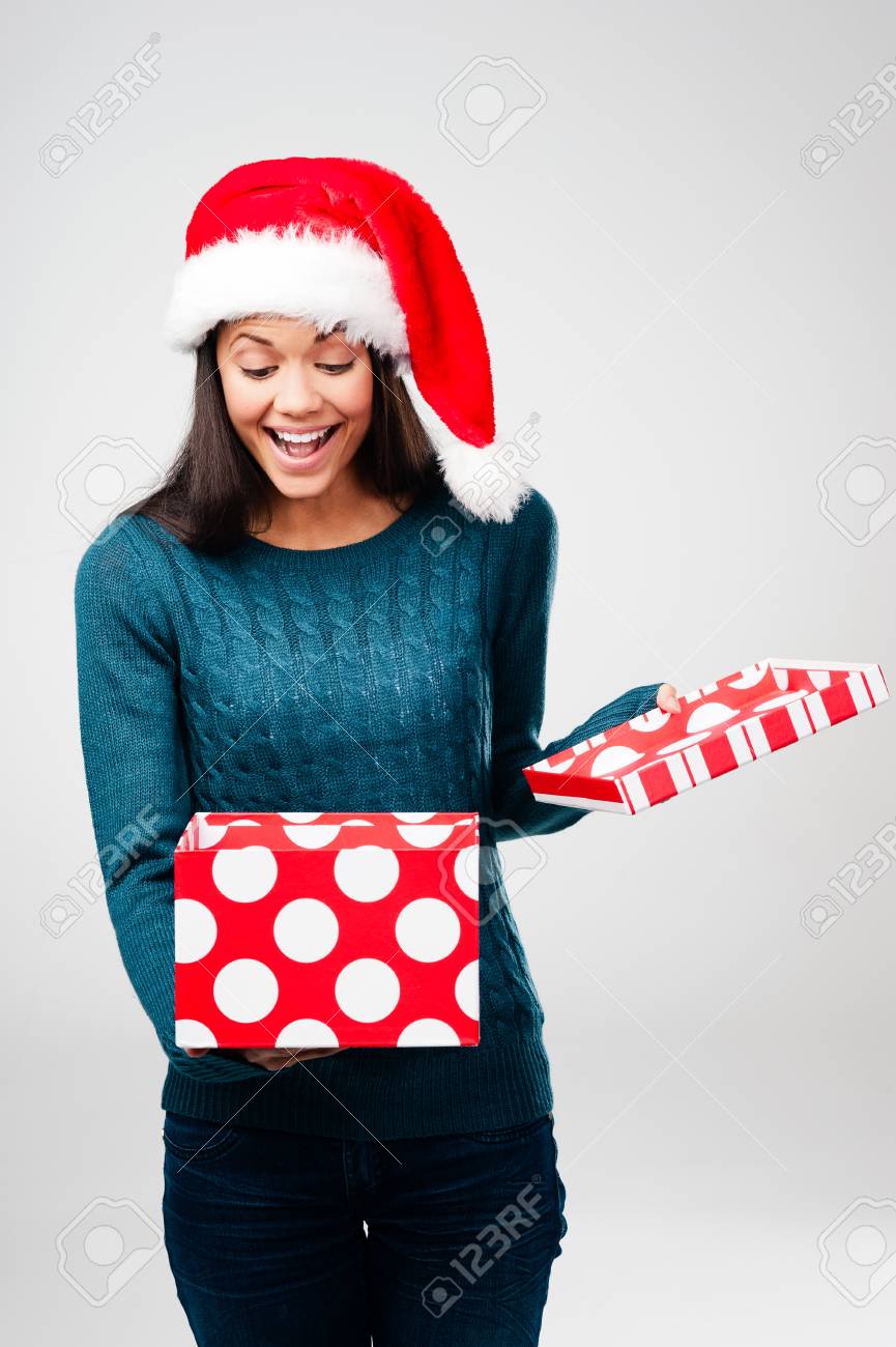 Joyeux Noel ! 16109168-woman-with-christmas-present-and-xmas-hat-having-fun-isolated-on-grey-background-Stock-Photo