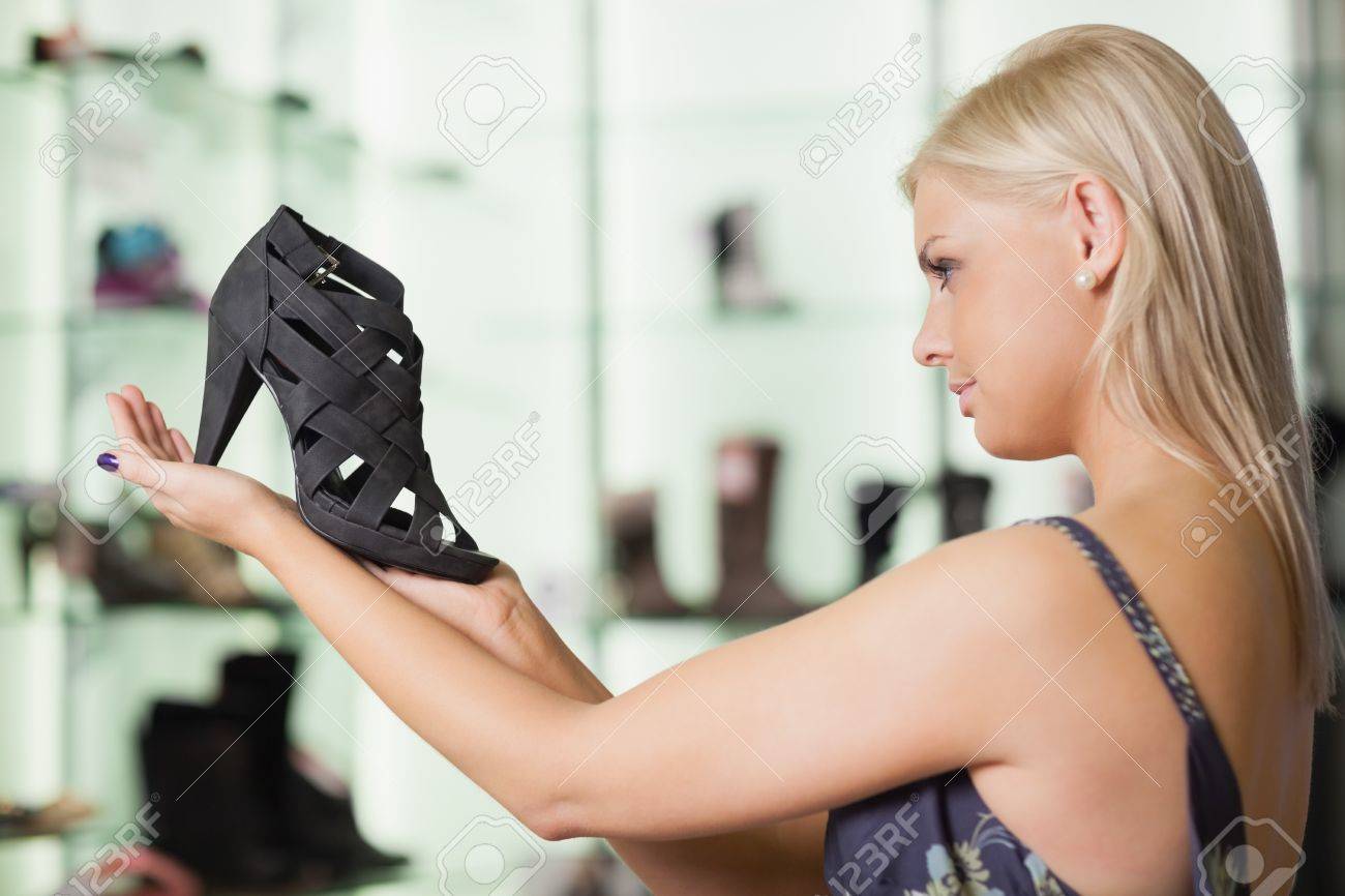 Paw Enforcement [BEARS WIN] - Page 31 15591018-Woman-looking-at-a-shoe-in-a-boutique-satisfied-Stock-Photo