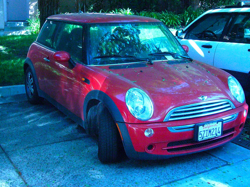 Red Mini Cooper in front of building 475 296968338_LVJaw-L