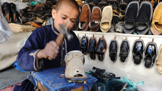 Prêt à payer ! Un-enfant-pakistanais-fabrique-des-chaussures