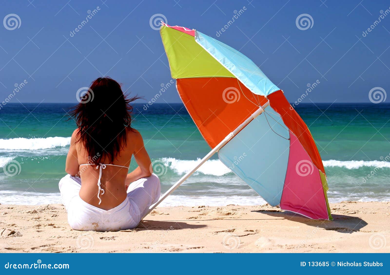 UN DESCANSO EN EL CAMINO - Página 5 Woman-sitting-under-colorful-parasol-white-sandy-beach-133685