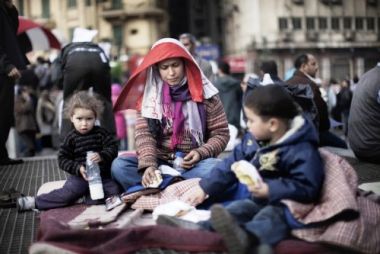 الطفل فى ميدان التحرير و ثوره 25 يناير ... An_egyptian_mother_sits_with_her_children_on_the_aeration_grid_of_the_cairo_metro_in_tahrir_square_04022011