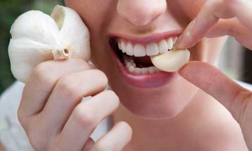 6 cách chữa đau họng không cần dùng thuốc GA6696_2iwoman-eating-garlic