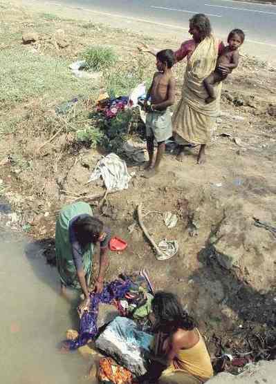 El poder de los opresores y el perecer de los necesitados Poverty_India_Mumbai_family_washing_clothes