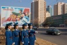 Four traffic ladies on a sunny day in Pyongyang. Official government posed picture with requisite propaganda poster in background.