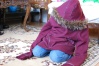 Nyah sitting on my moms living room floor with my zip-up jacket on.